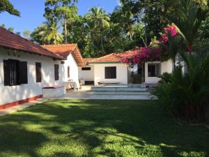 a courtyard of a house with pink flowers at Cinnamon lodge rooms in Koggala +14 photos