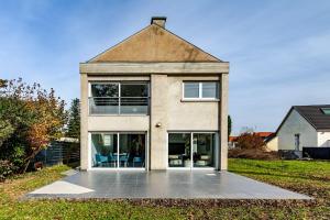 a large house with glass doors on a yard at Villa de rêve - Climatisation - Sauna - Spa - babyfoot - Arcade in Quatzenheim