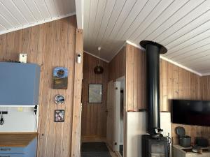 a room with a wood paneled wall with a stove at Mountain cabin in Lillehammer in Lillehammer