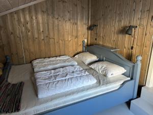 a bed with white sheets and pillows on it at Mountain cabin in Lillehammer in Lillehammer