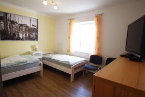 a room with two beds and a flat screen tv at Ferienwohnungen Alte Molkerei in Kläden