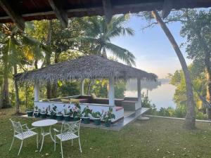 a gazebo with chairs and tables and a view of the water at Cinnamon lodge rooms in Koggala