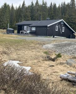 a black building with a bench in front of it at Mountain cabin in Lillehammer in Lillehammer