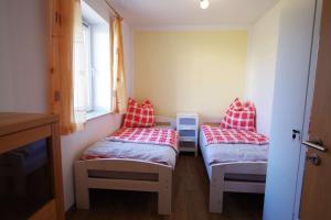 a room with two beds with red and white pillows at Ferienwohnungen Alte Molkerei in Kläden