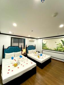 two beds in a room with roses on them at My House Hotel Hanoi in Hanoi
