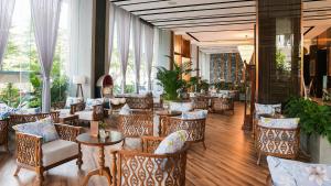 a restaurant with chairs and tables and windows at Centre Point Da Nang City Hotel - Afternoon Tea Inclusive in Danang