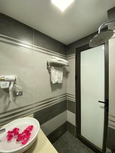 a bathroom with a sink with pink flowers in it at My House Hotel Hanoi in Hanoi +85 photos