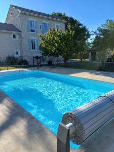 a swimming pool with a bench in front of a house at La bastide de Sarda in Montélimar