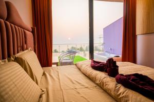 a hotel room with a bed and a large window at Coco 7 Beach Resort in Mandrem +45 photos
