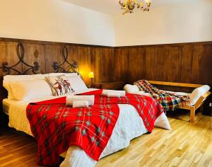 a bedroom with two beds with a red blanket at GuestHost - Il Dente del Gigante in Courmayeur