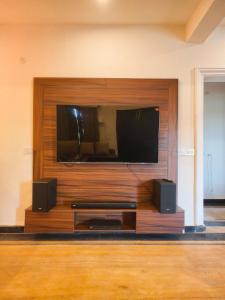 a flat screen tv on top of a wall at Basera by the Woods in Dehradun
