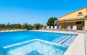 a swimming pool with chairs and a house at Can Paxaco in Alcudia