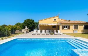 a villa with a swimming pool in front of a house at Can Paxaco in Alcudia