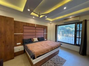 a bedroom with a large bed and a large window at Basera by the Woods in Dehradun