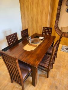 a wooden dining room table with chairs and a table at Basera by the Woods in Dehradun
