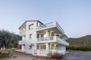una casa bianca con balconi e un vialetto d'accesso di Olive Waves apartments a Néa Péramos