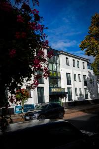 a black car parked in front of a white building at Hotel M24 - Alle Zimmer mit Küchenzeile & Self-CheckIn in Vechta