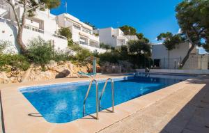 a swimming pool in front of a building at Playa D'or in Cala d´Or