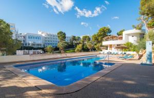 a swimming pool with blue water in front of a building at Playa D'or in Cala d´Or