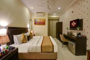 a hotel room with a bed and a desk at Anand Bhawan in New Delhi