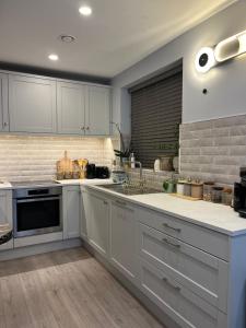 a kitchen with white cabinets and a stove top oven at Haven Stays - D15A5DF in Tyrrelstown