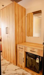 a kitchen with a microwave in a wooden cabinet at Coco 7 Beach Resort in Mandrem