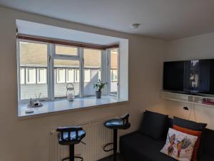 a living room with a couch and a window at Romeo's Retreat in Stratford-upon-Avon