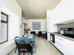 a kitchen and living room with a table and chairs at Calliste's House in Ioulis