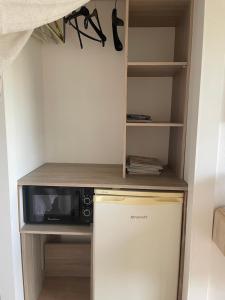 a kitchen with a microwave and a small refrigerator at La Parenthèse de Victoire in Aigues-Mortes