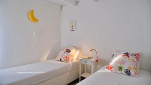 a room with two beds and a table with a lamp at Calliste's House in Ioulis +38 photos