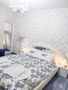 a bedroom with a large bed with a floral bedspread at Guesthouse Jasmin in Sapareva Banya