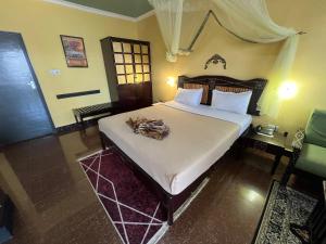 a bedroom with a large bed with a white comforter at Rusty Rock Beach Resort & Spa in Mwanza +43 photos