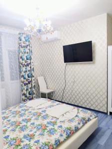 a bedroom with a bed with a tv on the wall at Guesthouse Jasmin in Sapareva Banya