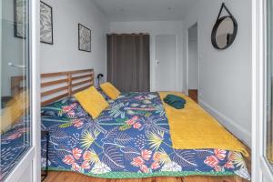 a bedroom with a bed with a colorful comforter at Résidence Celestins - Appartements centre avec parking in Vichy