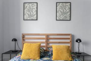 a bedroom with a bed with yellow pillows and two lamps at Résidence Celestins - Appartements centre avec parking in Vichy