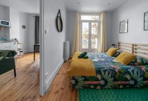a bedroom with a bed with a colorful bedspread at Résidence Celestins - Appartements centre avec parking in Vichy