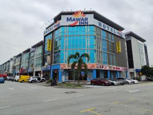 a large building with cars parked in a parking lot at Hotel Mawar Inn in Jenjarum