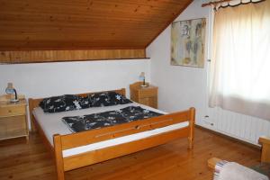 a bedroom with a bed and a wooden ceiling at Penzion Sinji vrh in Zoll