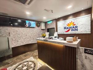 a lobby of a mayaya inn with a reception counter at Hotel Mawar Inn in Jenjarum