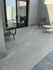 a room with two benches and a table on a tile floor at شقق سكنية بالخالدية in Al ‘Awālī