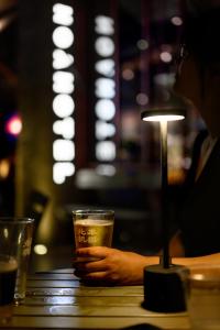 a person sitting at a table with a glass of beer at NOA Hotel XIAMEN in Xiamen