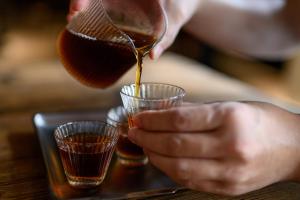 a person pouring a drink into glasses on a table at NOA Hotel XIAMEN in Xiamen
