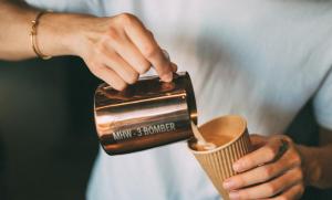 a person is holding a cup of coffee at NOA Hotel XIAMEN in Xiamen