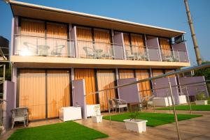 a building with a balcony with tables and chairs at Coco 7 Beach Resort in Mandrem