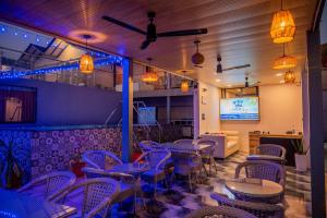 a dining room with tables and chairs and a tv at Coco 7 Beach Resort in Mandrem