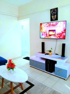 a living room with a flat screen tv on a wall at Ladine Homestay - Ferrum Apartment in Eldoret
