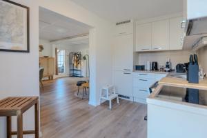 a kitchen with white cabinets and a wooden floor at Central City Apartment 1 with Mountain View in Zweisimmen