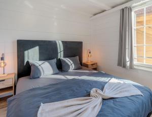 a bedroom with a large bed with a blue blanket at Central City Apartment 1 with Mountain View in Zweisimmen