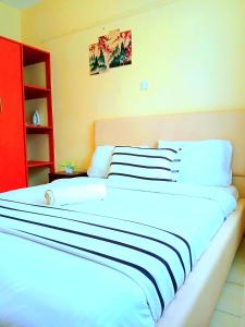 a bedroom with two white beds and a red shelf at Ladine Homestay - Ferrum Apartment in Eldoret