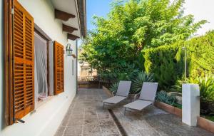 a patio with two chairs and a window at Es Baladre Beach in Alcudia